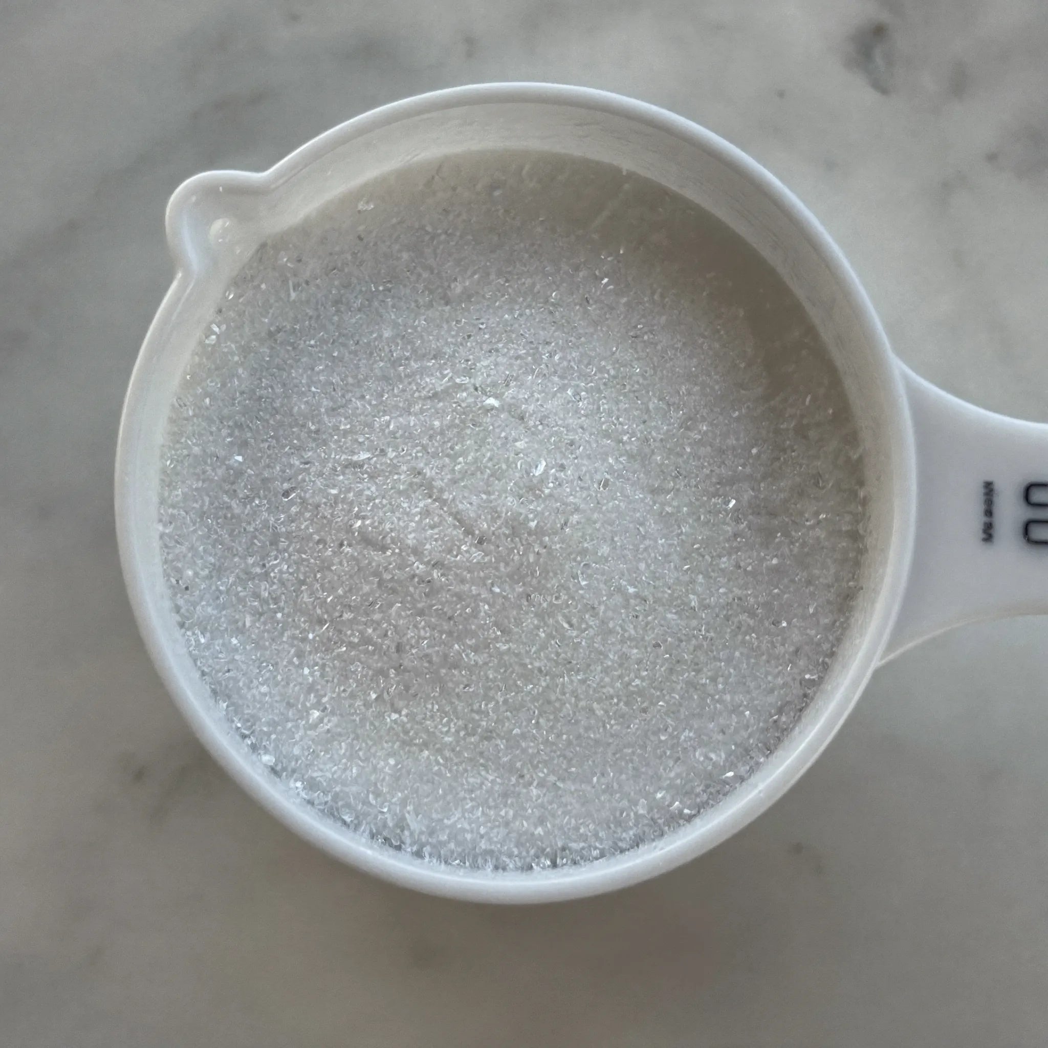 A scoop of pure white taurine powder